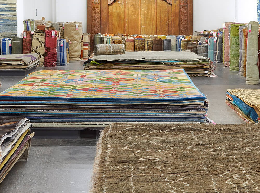 Wahi Rugs warehouse with rolled and stacked rugs